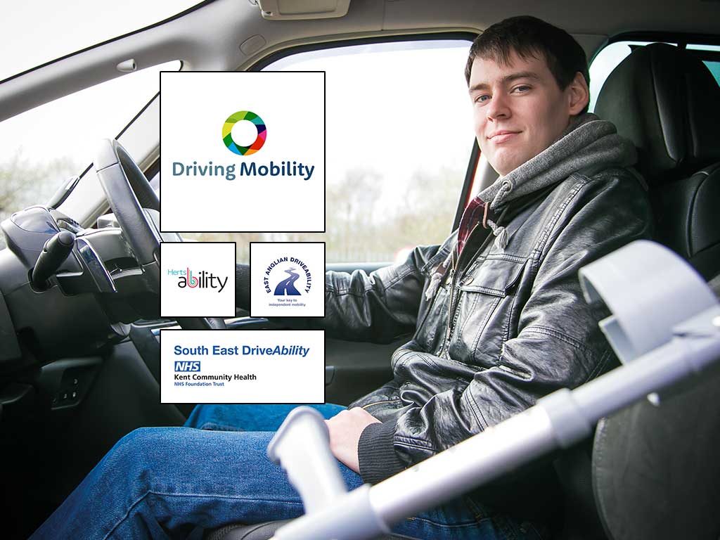 A young man seated in a car facing the camera.