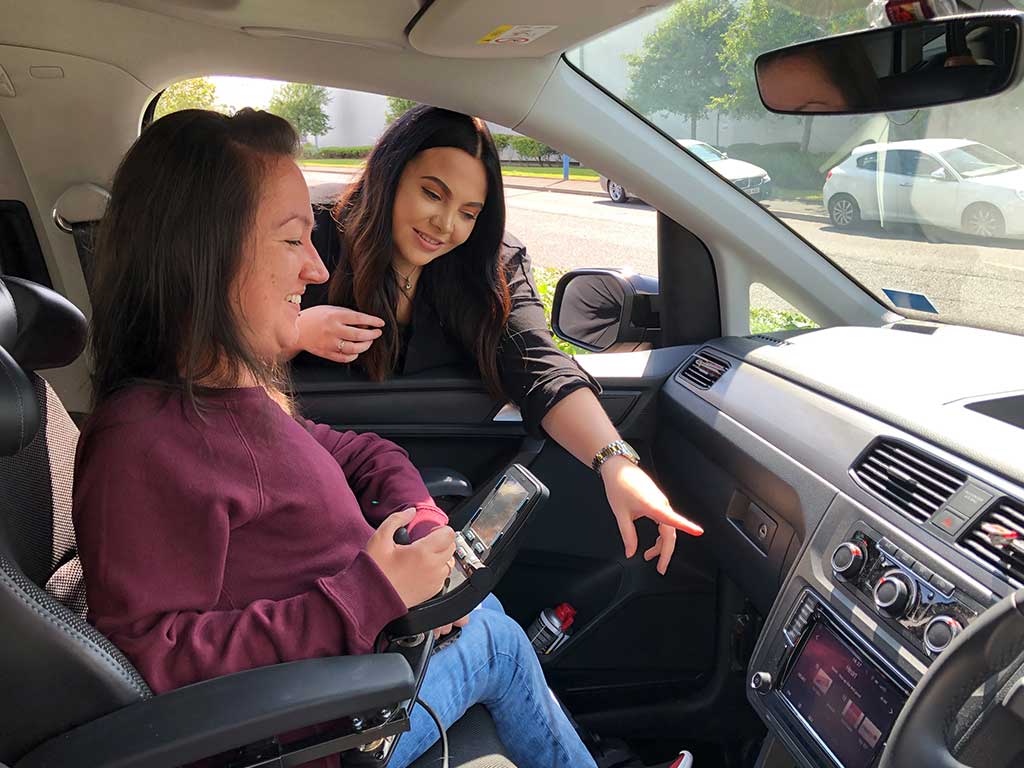 A young woman receiving instruction for using her adapted vehicle.